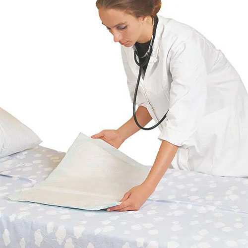 weiße Krankenunterlagen die von einer Ärztin in weißem Kittel und Stetoskop um den Hals auf ein Krankenbett mit Wolkenbettwäsche gelegt wird.jpg